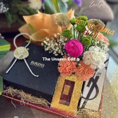 I take great pride in creating gifts for the groom that are both sophisticated and personal. Here, I have styled high-end gifts like a Rado watch and YSL fragrance with fresh, vibrant florals and a custom name tag, ensuring the presentation is as memorable as the gift itself.