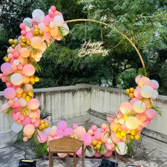 This angle shows how uplighting can enhance an outdoor balloon decoration at dusk. The lights make the colors of the balloons on the ring arch appear even more vibrant.