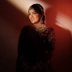 Another beautiful portrait of the smiling bride. This image clearly shows the defined yet natural eye makeup and the perfect shade of lipstick chosen to match her royal velvet lehenga.
