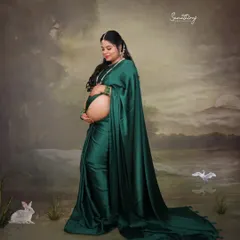 Draped in a stunning emerald green satin saree, this mother-to-be traveled from Tamil Nadu for her shoot. Her portrait is a blend of modern elegance and traditional grace, set against a dreamy, artistic backdrop.