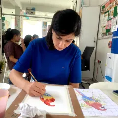 A student in our short-term course working on a detailed watercolor painting of a parrot. These courses allow you to tackle more complex and rewarding projects.