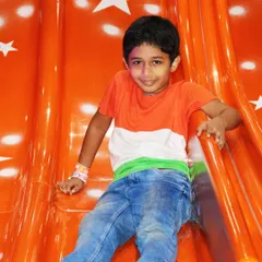 A young boy dressed in the tricolor enjoys the slide during our Independence Day event. We encourage everyone to get into the festive spirit.