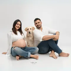 A classic family photo. The couple and their dog pose for a beautiful, relaxed portrait that captures their easygoing connection and happiness.