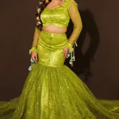 A full view of the modern lime green fish-cut lehenga, perfect for a Mehendi or cocktail night. The look is accessorized with floral kaleeras and earrings for a touch of tradition.