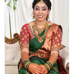 A picture perfect moment from an engagement. The rich green silk saree is draped to showcase the intricate blouse work, and the pleats are set to create a graceful fall as she sits.