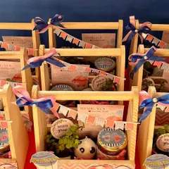 These budget-friendly baby shower hampers feature a cute elephant theme. Each pinewood basket contains a resin planter with a jade plant, a jar of handmade chocolates, and a personalized thank you card.