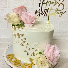Pure elegance. This vanilla cake is decorated with fresh roses, delicate sprinkles, and a touch of gold leaf for a sophisticated birthday celebration.