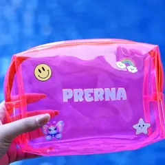 A close-up of a bright pink personalized jelly pouch. It's customized with the name 'Prerna' and decorated with cute patches like a smiley face, a rainbow, and a butterfly.