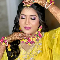 A creative pose showing the intricate floral hathphool and the beautiful mehndi design on her hands.