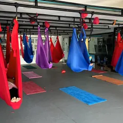 A moment of deep relaxation in Savasana, cocooned in the aerial hammocks after an intense practice. This is a key part of our training, teaching students how to guide others into a state of complete surrender.