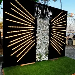 This "Fly High" photo booth is all about making a statement. The wing-like LED design and shimmering silver backdrop create a glamorous and fun spot for guests to capture memories.