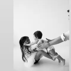 The sweet, protective embrace of an older sister. This unposed moment, with a father's hands gently guiding them, is the kind of raw, authentic beauty I love to capture in my family sessions.