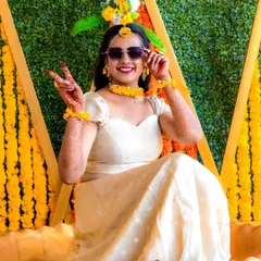 A stylish portrait of the bride at her Haldi ceremony. The vibrant yellow decor and her happy pose perfectly capture the festive spirit of the day.