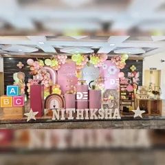 A beautiful fairy-themed party for Nithiksha's third birthday. The setup uses a soft color palette of pink and yellow, with a custom backdrop, rustic props like wooden crates, and large 'ABC' blocks for a playful touch.