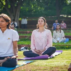 Participants find their inner calm during an outdoor yoga session. We often hold classes in nature to help deepen the connection between the self and the environment, enhancing the benefits of meditation and pranayama.