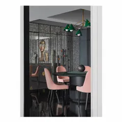 This dining area is defined by bold choices. A large, grey monolith dining table is paired with soft pink chairs and an olive green leather chandelier. The entire scene is reflected in an antique mirrored wall, which adds depth and a touch of glamour to this modern dining space.