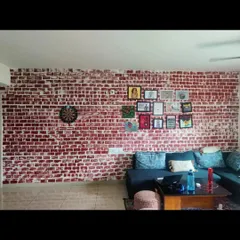 An exposed brick wall adds a rustic, industrial charm to any room. We created this realistic brick effect by hand, giving the living space a warm and textured feature wall without the cost of actual brickwork.