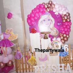This Barbie party setup features multiple princess cutouts and a picket fence, creating a lovely scene for a 6th birthday celebration.