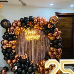 For milestone anniversaries, we design elegant backdrops that celebrate the occasion. This 25th-anniversary setup includes a circular balloon arch in black and rose gold, a custom neon sign, and large, illuminated marquee numbers.
