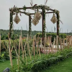 A side view of the rustic mandap, showing how the tall pampas grass creates a natural aisle and frames the structure beautifully against the green landscape.