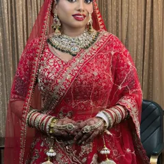 A full-length view of a stunning bride in her red lehenga. The complete look, from the makeup to the jewelry and outfit, comes together to create a picture of bridal perfection.