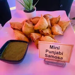 A classic snack, perfected. Our Mini Punjabi Samosas are crispy, flaky, and filled with a savory potato and pea mixture, served with a fresh mint-coriander chutney.