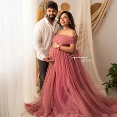 A classic couple's portrait in our boho-themed studio, with both partners gently holding the baby bump.