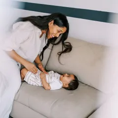 A mother and her baby sharing a laugh on the sofa. The beautiful natural light in their home made this indoor lifestyle shoot feel truly magical.