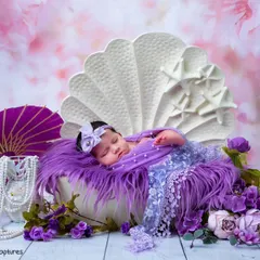 A wide shot of the purple shell theme, showing the newborn sleeping peacefully. The setup includes a purple parasol and pearls, creating a rich, royal look.