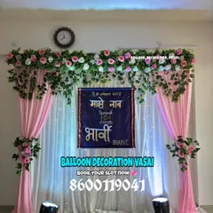 A traditional Marathi naming ceremony (Barsa) backdrop. The setup includes elegant pink drapes, floral arrangements, and a custom banner in Marathi that says "Majhe Naam" (My Name) with the baby's name, Bharvi.