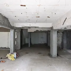 A view of the raw, untouched interior before our work began. This image documents the original state of the space, with its exposed concrete beams and columns that we later integrated into the design.
