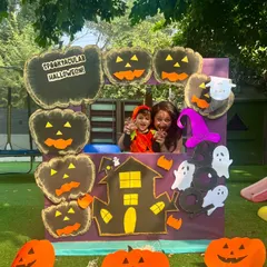 All smiles at the Halloween workshop. This little pumpkin and his mom are enjoying our custom-made photo booth, perfect for capturing party memories.