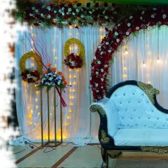 An alternate view of a classic red and white floral stage setup, showing the placement of the sofa, lighting, and decorative stands.