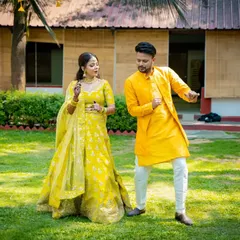 A fun, dancing shot of the couple in their matching yellow Haldi outfits, perfectly capturing the celebratory spirit of the day.