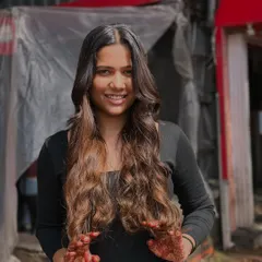 A beautiful, smiling portrait of a client loving her fresh balayage and waves.