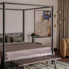 The parent's bedroom in the Aikaa villa, featuring a modern four-poster bed and a bold piece of art. We balanced the strong lines of the furniture with soft textiles and a patterned rug for a sophisticated yet comfortable feel.