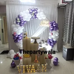 A chic and modern ring decoration with purple and white balloons. The white curtain backdrop and simple props create a very clean and elegant look.