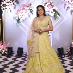 This lehenga features a lovely chevron pattern on the skirt in shades of yellow and mint green, offering a subtle yet unique design. It's paired with a matching embroidered blouse.