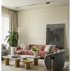 This living room in a Mumbai apartment is a study in serene sophistication. A soft pink sofa adds a touch of color to the neutral palette, while the clean lines of the wall molding and the abstract art create a backdrop of quiet elegance. The space is designed to feel like a sanctuary.