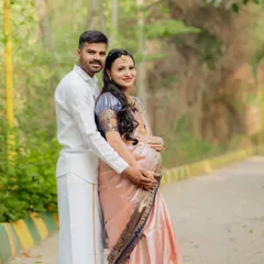 Embracing tradition with grace. This outdoor couple's portrait captures the elegance of a classic silk saree, blending cultural heritage with the natural beauty of a park setting for a timeless maternity photo.