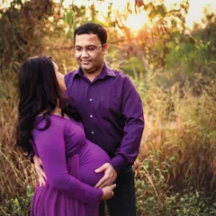 A beautiful moment of connection between an expecting couple, captured during golden hour. The warm light and natural setting create a romantic and intimate atmosphere for this outdoor maternity portrait.