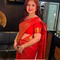 A gorgeous mother of the bride in a classic red saree. The makeup is elegant and enhances her natural grace.