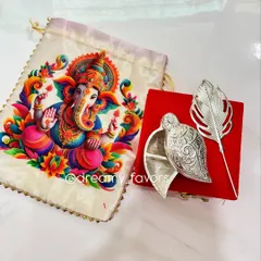 This is one of my favorite return gifts for Ganesh Chaturthi. It features an elegant silver-coated Tilak Dibbi box paired with a vibrant Ganpati print potli bag. It's a beautiful blend of tradition and artistry that your guests will cherish.