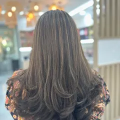 A perfect example of our sun-kissed highlights. We added fine, natural-looking streaks to create depth and texture, finished with a layered cut and soft curls. This is a popular choice for clients who want to brighten their look without a drastic change.