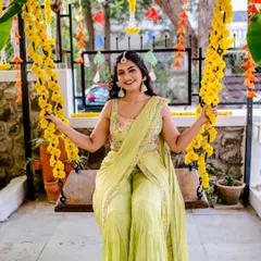 A beautiful portrait of the bride during her Mehendi ceremony, seated on a swing adorned with marigolds, looking absolutely radiant.