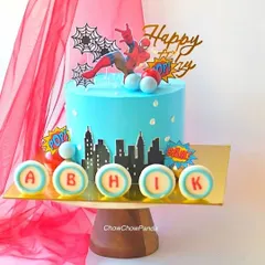 Here's a popular Spider-Man birthday cake design. This one features a city skyline, fun comic-style toppers, and personalized name discs, all on a bright blue buttercream base. The flavour for this cake was Strawberry.