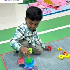 A new student is already focused on his work, stacking blocks with concentration. Our welcoming environment helps children feel comfortable and ready to learn from day one.