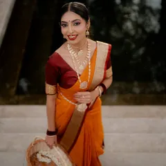 An elegant portrait featuring a classic orange and maroon saree. I used soft lighting to highlight the traditional jewelry and the model's graceful expression, with a basket of flowers adding a touch of softness.
