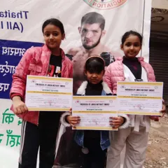 The next generation of champions. These three young girls proudly display their certificates, proving that martial arts is for everyone.