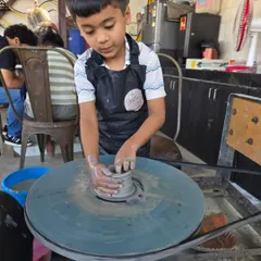 Learning the ropes of wheel throwing. This young boy is getting the hang of centering the clay, the first and most important step in pottery. I ensure every child gets one-on-one attention.
